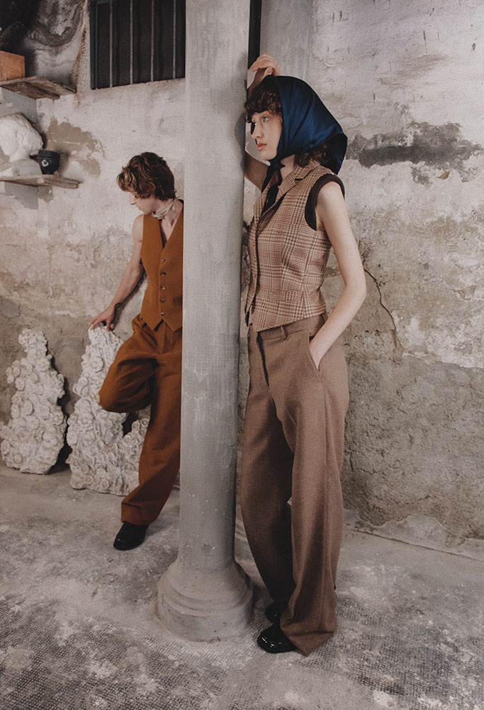 Models leaning against a column, she with a neckerchief on her head and Barcelona pants, release ARS01, outfit 7 women.